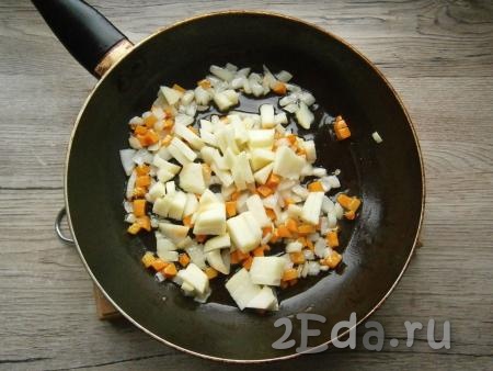Обжарить лук с морковью на среднем огне 2-3 минуты, далее добавить очищенное от семян и кожуры и нарезанное кубиками кислое яблоко, обжарить все вместе еще 2-3 минуты, помешивая.