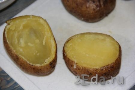 Горячий картофель переложить на разделочную доску, срезать верхушку и с помощью ложки вынуть часть мякоти. Сформировать лодочки (как на фото).