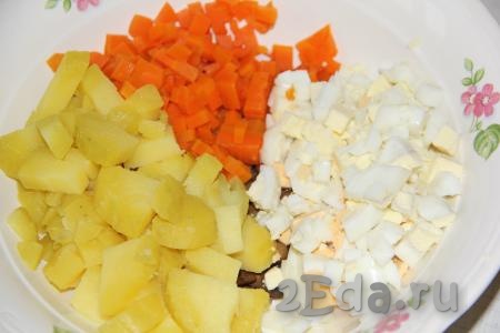 Очищенные яйца тоже нарезать средними кубиками и добавить в салат.