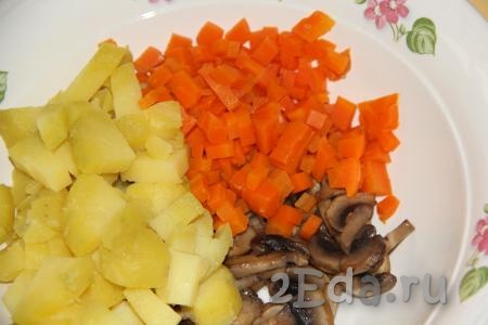 Варёную морковь очистить, нарезать кубиками и выложить в салат из картошки и шампиньонов.