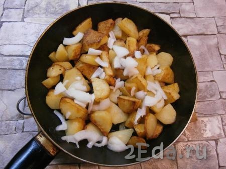 В сковороду с обжаренной картошкой добавить очищенный и нарезанный репчатый лук, перемешать, посолить, готовить далее еще минут 5-7 на среднем огне.