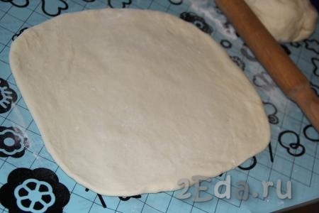 Стол (или силиконовый коврик) присыпать мукой, тесто раскатать в прямоугольный пласт. Раскатывать тонко тесто не нужно.