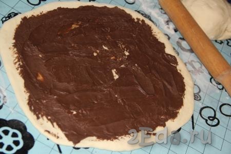 Смазать прямоугольный пласт шоколадной пастой, оставляя чистыми края (как на фото).