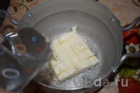 Сливочное масло нарежем кубиками в небольшую толстостенную кастрюльку, добавим соль и зальем водой.