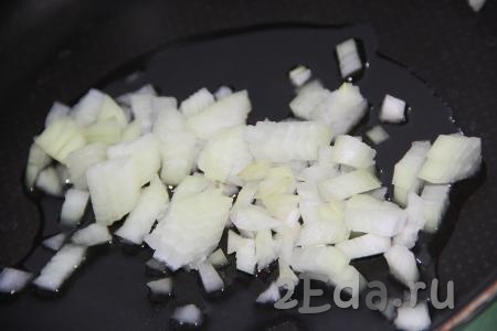 В сковороду добавить 1 столовую ложку растительного масла, выложить мелко нарезанный лук.