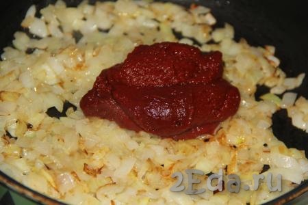 Обжарить лук, помешивая, до золотистого цвета, затем добавить томатную пасту.