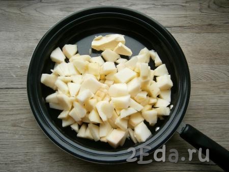 Для приготовления начинки очищенные от кожуры и семян яблоки нарезать кубиками. Нарезанные яблоки и сливочное масло выложить в сковороду и отправить на средний огонь.