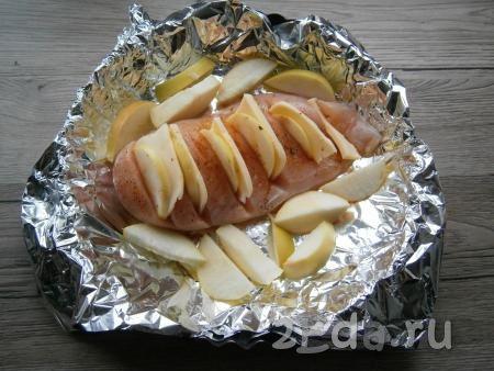 В разрезах разместить по кружочку яблока и ломтику сыра. Оставшиеся яблоки очистить от семян и нарезать дольками, которые выложить рядом с курицей.