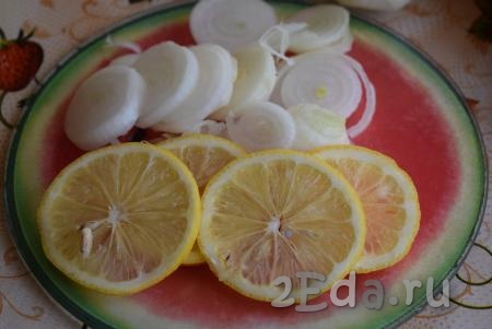 Репчатый лук очистим от кожуры и нарежем на тонкие кольца. Половину лимона нарежем на дольки. Из второй половины лимона нужно выжать сок прямо в миску с мясом.