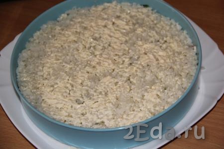 Поверх огурцов выложить оставшийся рис, утрамбовать и смазать творожным сыром.