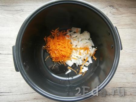 Растительное масло налить в чашу мультиварки. Морковь и лук очистить. В чашу мультиварки в масло выложить натертую на крупной терке морковку и нарезанный произвольно лук.