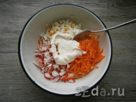 Морковь, яйца, крабовые палочки и плавленный сыр сложить в миску, добавить подготовленную заправку.