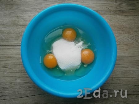 В отдельную миску разбить яйца, всыпать сахар и ванильный сахар.