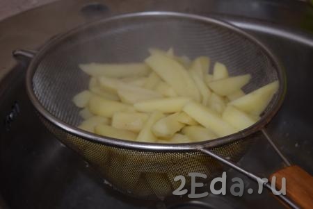 Дольки картофеля откинем на дуршлаг и оставим на несколько минут, для того чтобы вся жидкость стекла.