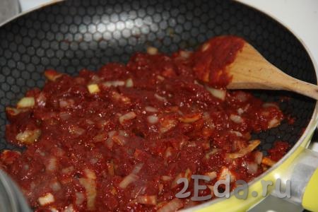 Лук с томатной пастой обжарить на среднем огне в течение 1-2 минут, периодически помешивая.