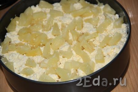 Открыть банку с консервированными ананасами, жидкость слить. Выложить поверх теста творожную начинку вперемешку с кусочками ананаса.