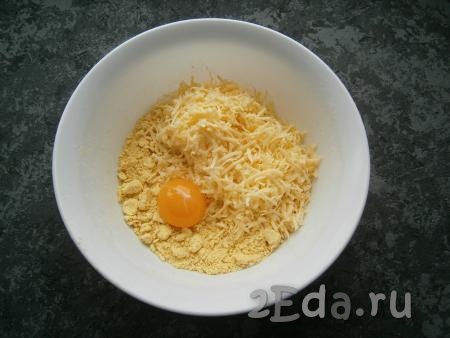 Добавить сырой желток и натертый на мелкой (или средней) терке сыр.