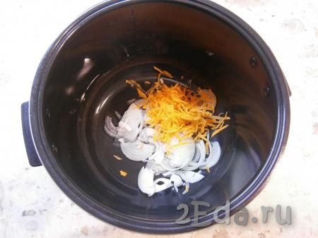 Растительное масло влить в чашу мультиварки, затем выложить лук, нарезанный полукольцами (или четвертинами), и натертую на крупной терке морковь.