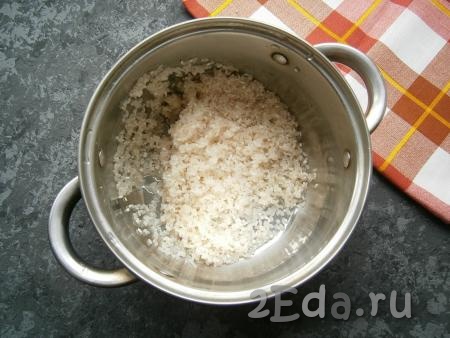 Рис всыпать в кастрюлю с толстым дном. Теперь его нужно очень хорошо промыть водой. Промывать рис нужно несколько раз (лучше 3-4 раза), до тех пор, пока вода не станет полностью прозрачной. Далее воду полностью слить.