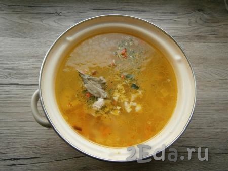Добавить в суп специи, лавровый лист и измельченный чеснок. Варить суп на слабом огне 10 минут, затем выключить огонь.