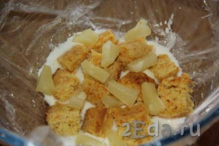 Затем выложить слой из кусочков бисквита и кусочков ананасов, полить сметанным кремом.