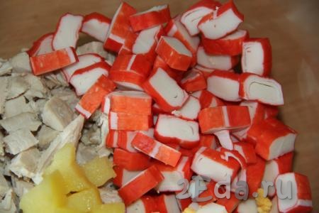 Крабовые палочки заранее разморозить при комнатной температуре, затем нарезать на средние кусочки и выложить в салат из картошки и куриной грудки.