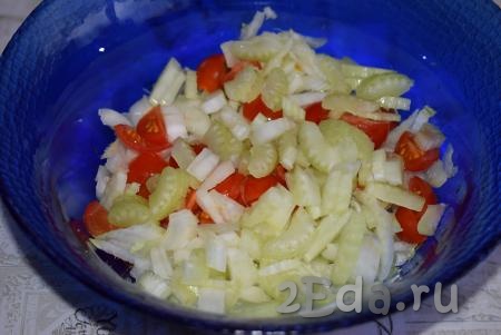 Складываем нарезанные помидоры, пекинскую капусту и стебли сельдерея в салатник и аккуратно перемешиваем салат.